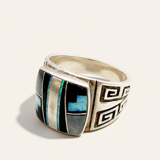 silver ring with black and blue stone on a beige background