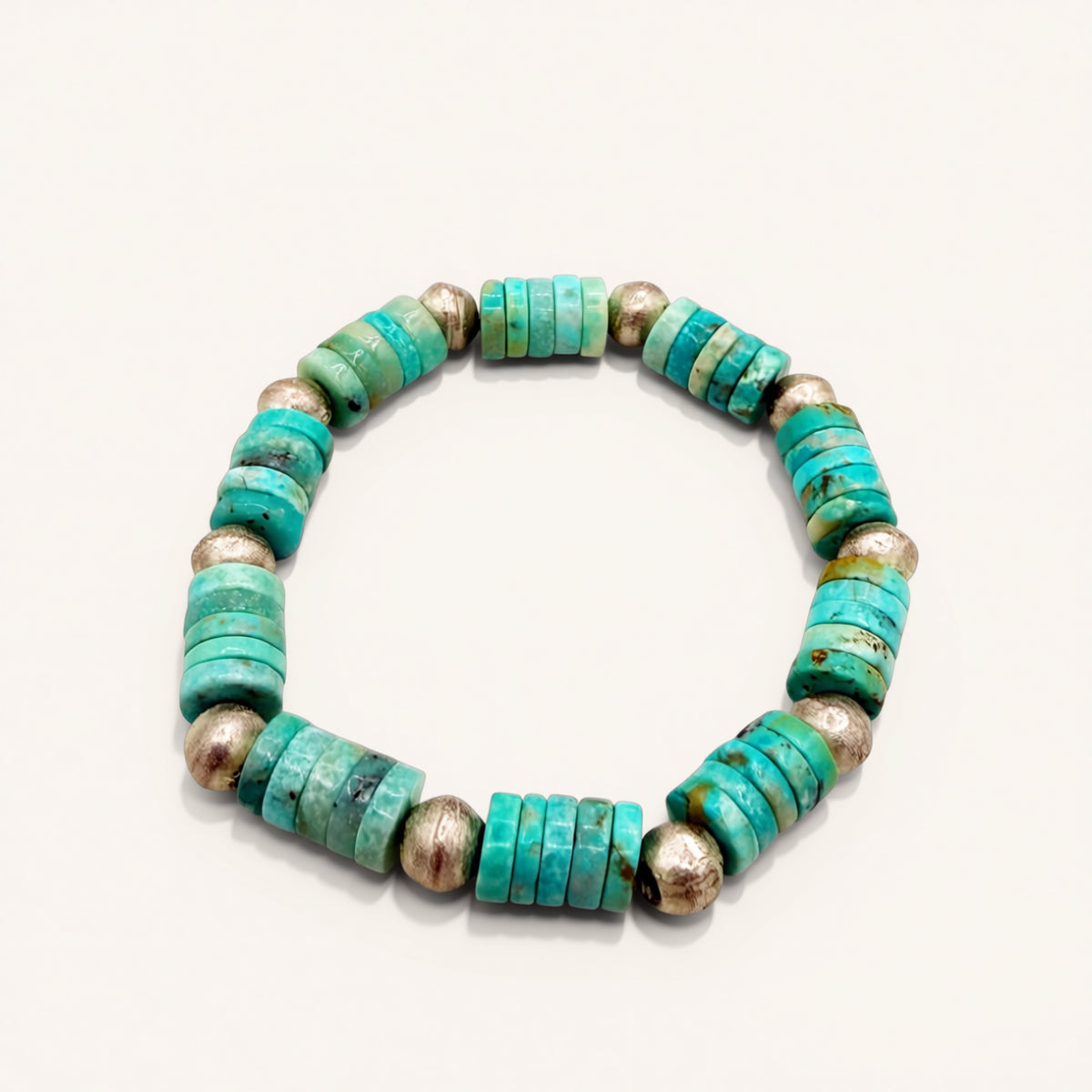 Turquoise and silver beaded bracelet on a white background