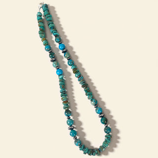 Turquoise beaded necklace on a beige background