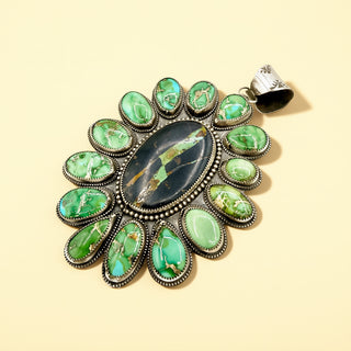Jewelry pendant with green stones on a beige background