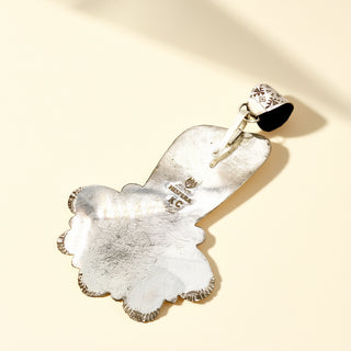 Silver pendant stamp on a beige background