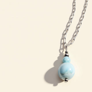 Necklace with a blue pendant on a beige background