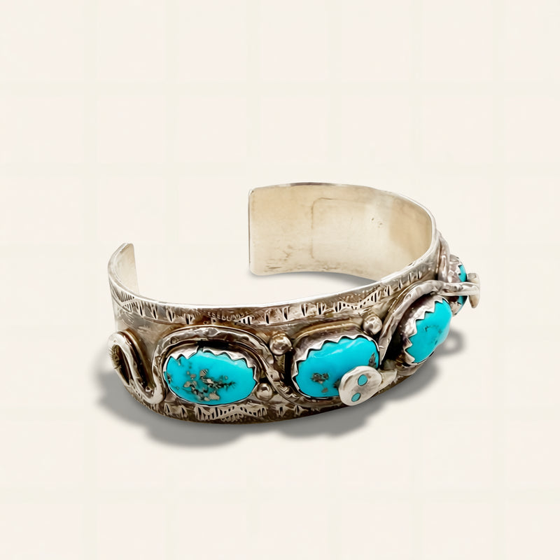 Silver bracelet with turquoise stones on a beige background
