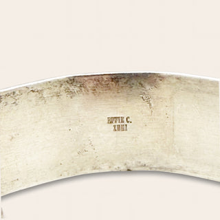 Close-up of a silver ring with engraved text on a white background
