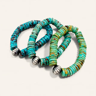 Turquoise beaded bracelets with silver accents on a light gray background