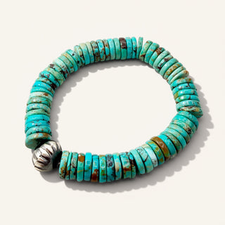 Turquoise beaded bracelet with a silver clasp on a white background