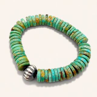 Turquoise beaded bracelet with a silver clasp on a white background