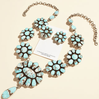 Turquoise necklace with floral designs on a beige background