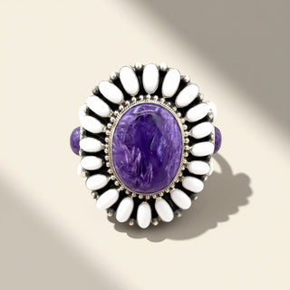 Ring with purple stone and white beads on a beige background