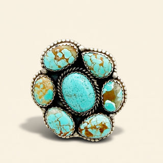 Turquoise stone ring with silver band on a beige background