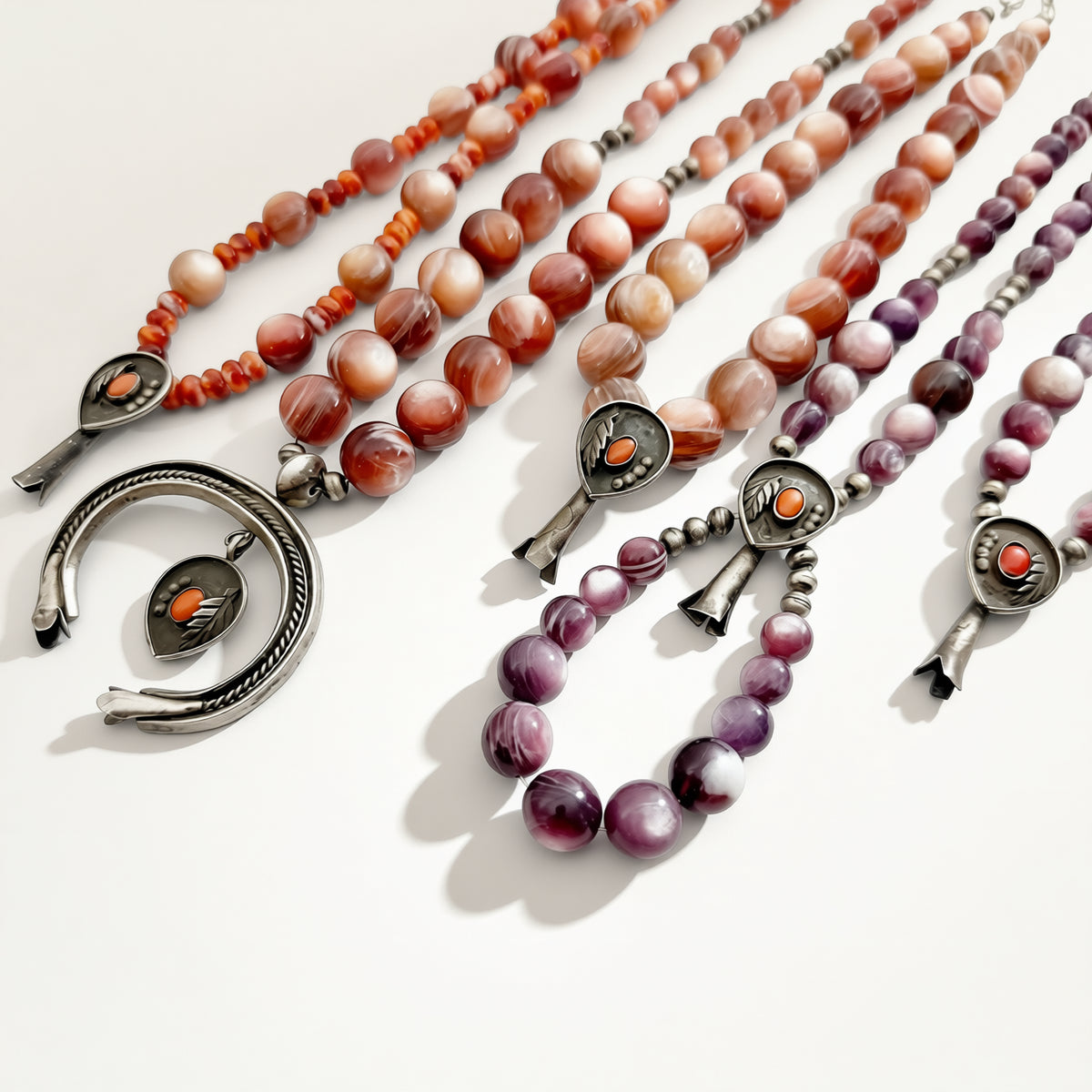 Red and purple beaded jewelry on a beige background