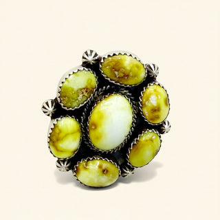 Ring with yellow stone inlays on a beige background