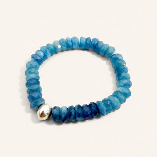 Blue beaded bracelet with a silver accent on a white background