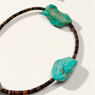 brown jewelry with turquoise stones on a beige background