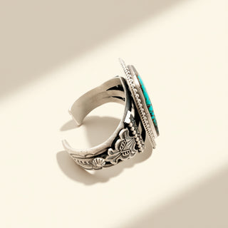 Silver cuff with turquoise stone on a beige background