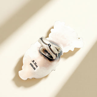 Close-up of a silver ring on a beige background