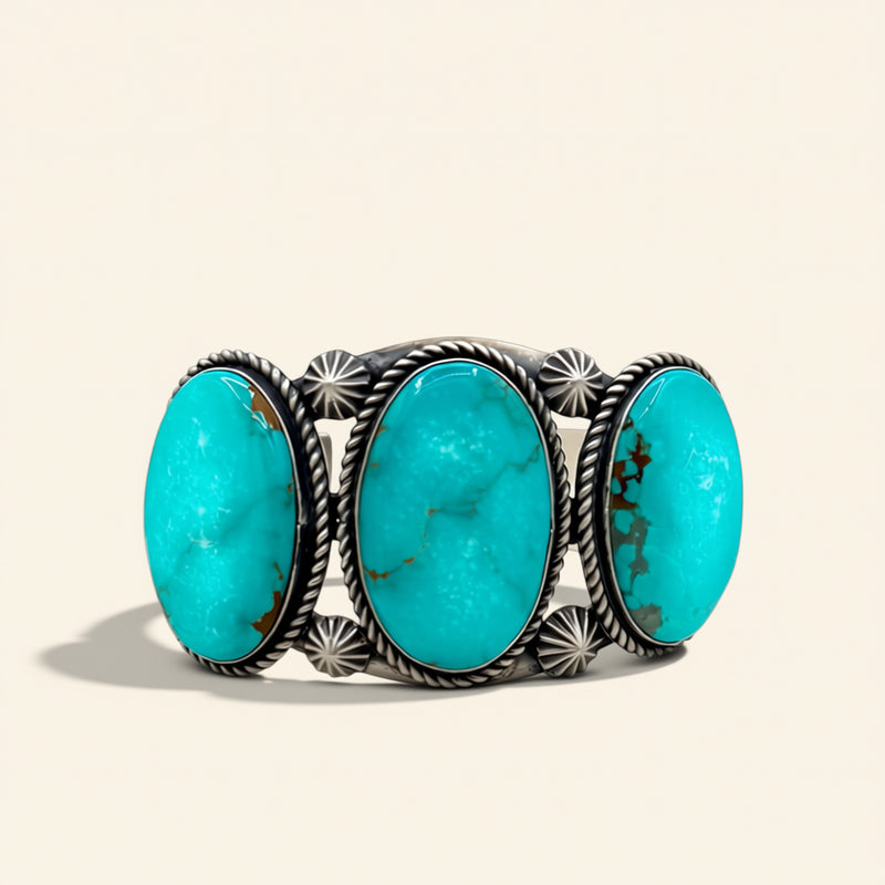 Turquoise stone cuff with silver band on a beige background