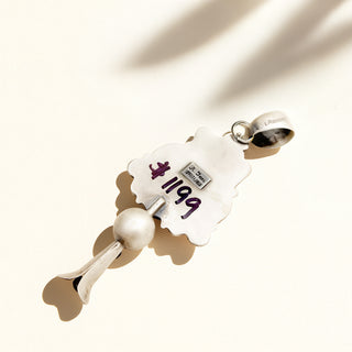 Close-up of a white and silver pendant with '1199' on a light background