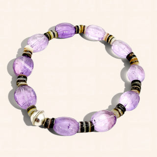 Purple beaded bracelet with black and gold accents on a white background