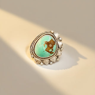 Silver ring with turquoise stone on a beige background