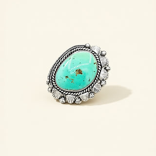 Silver ring with a turquoise stone on a beige background