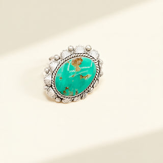 Silver ring with a turquoise stone on a beige background