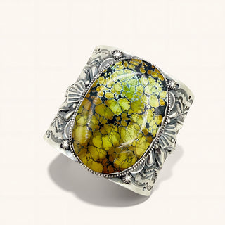 Silver ring with a large green stone on a white background