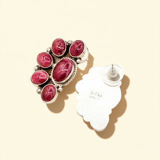 Earrings with purple  gemstones on a beige background