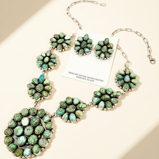 Jewelry set with green gemstones on a beige background