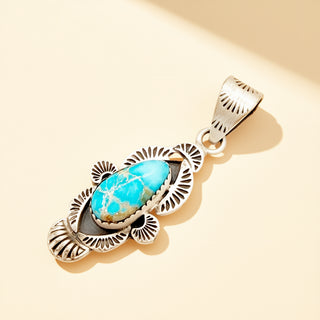 Silver pendant with a turquoise stone on a beige background