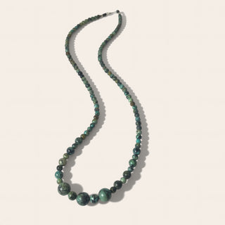 Necklace with green beads on a white background
