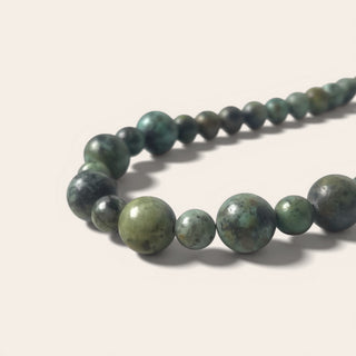 Green beaded necklace on a light background