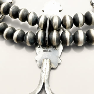 silver jewelry with stamp on a beige background