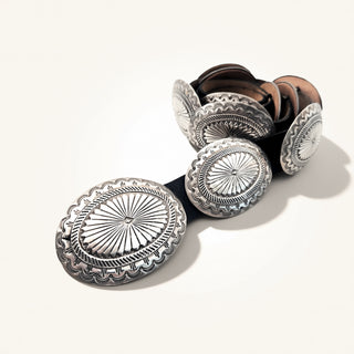 Belt with silver concho-style belt buckles on a white background