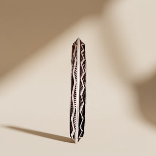 Silver cuff with designs on a beige background