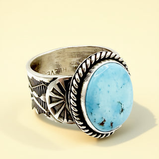 Silver ring with a blue stone on a beige background