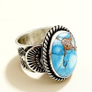 Silver ring with blue stone on a beige background