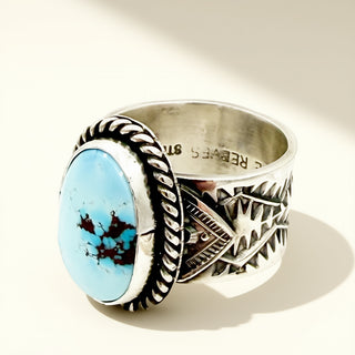 Silver ring with a blue stone on a beige background