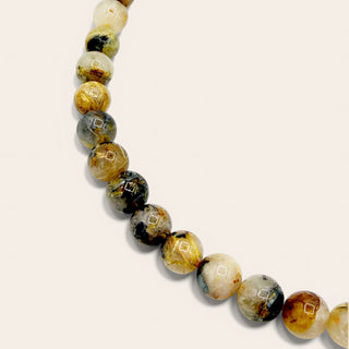 yellow and black beaded jewelry on a beige background