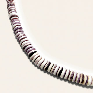 purple and white beaded jewelry on a beige background