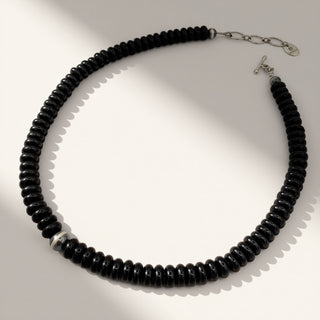 black beaded necklace on a beige background
