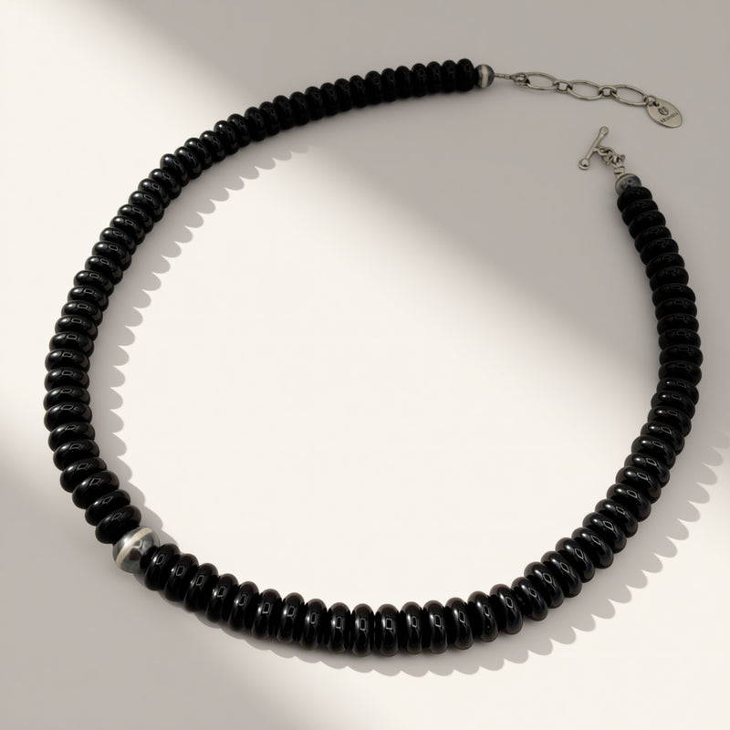 black beaded necklace on a beige background