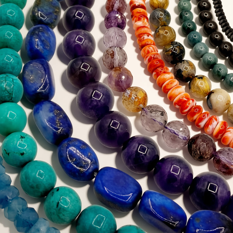 multiple bead strands of various colors on a beige background