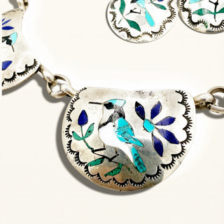 silver jewelry with blue bird on a beige background