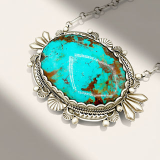 silver jewelry with turquoise stone on a beige background