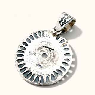 silver pendant on a beige background