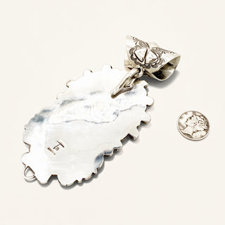 Silver jewelry piece with intricate design on a white background