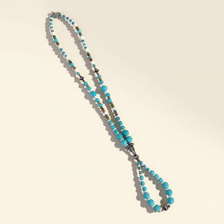 Turquoise beaded necklace on a beige background