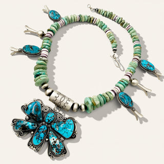 green beaded necklace with butterfly turquoise pendant on a beige background