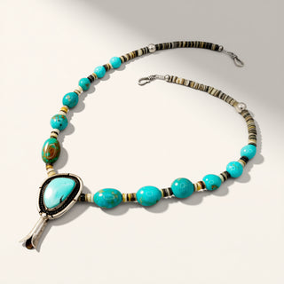 turquoise beaded necklace with turquoise pendant on a beige background